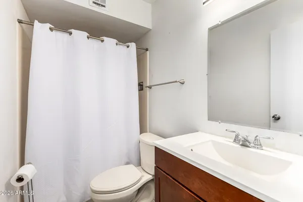 a bathroom with a granite countertop sink toilet and a mirror