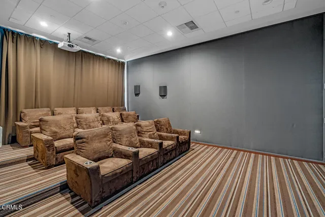 a media room with lots of chairs and wooden floor