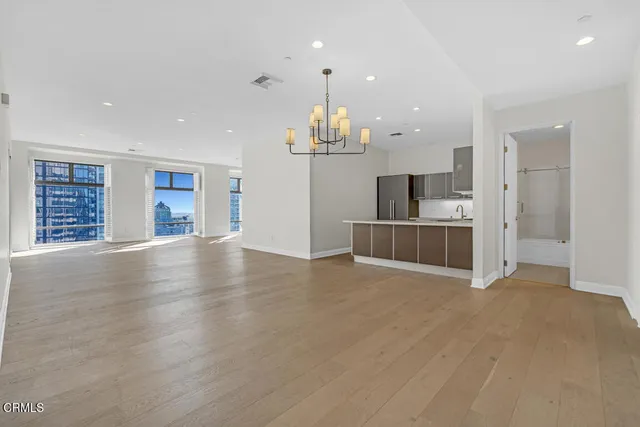 a view of empty room with wooden floor and window