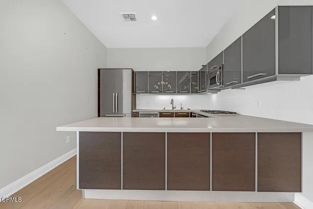 a kitchen with stainless steel appliances a refrigerator and a stove