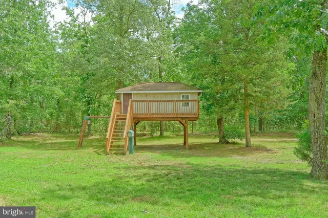 a view of a house with a yard deck and a patio