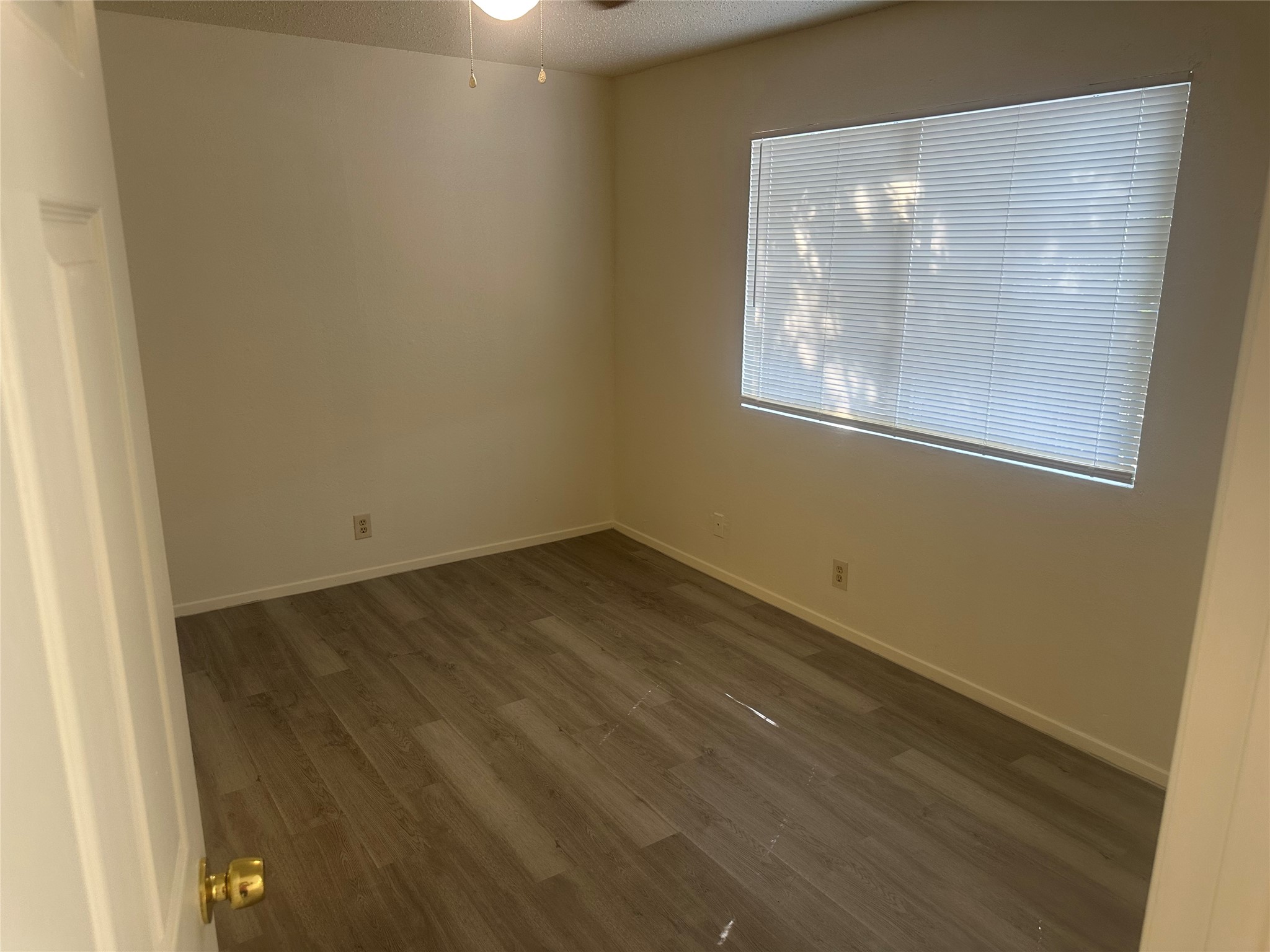 2602 South Bagdad Road, Unit B Leander, TX 78641 - Photo 8 of 23 A windowed bedroom features textured plaster walls and updated wood plank flooring.