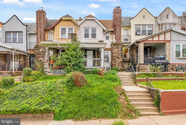 a front view of a house with a garden and plants