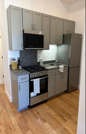 a kitchen with stainless steel appliances granite countertop a stove a refrigerator and a microwave