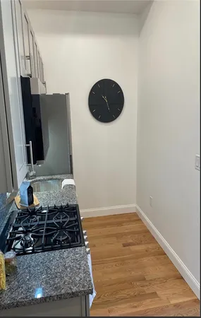 a bathroom with a granite countertop toilet a sink a mirror and a shower