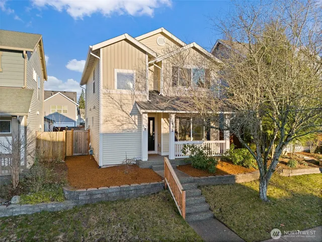 a view of a white house with a yard and plants