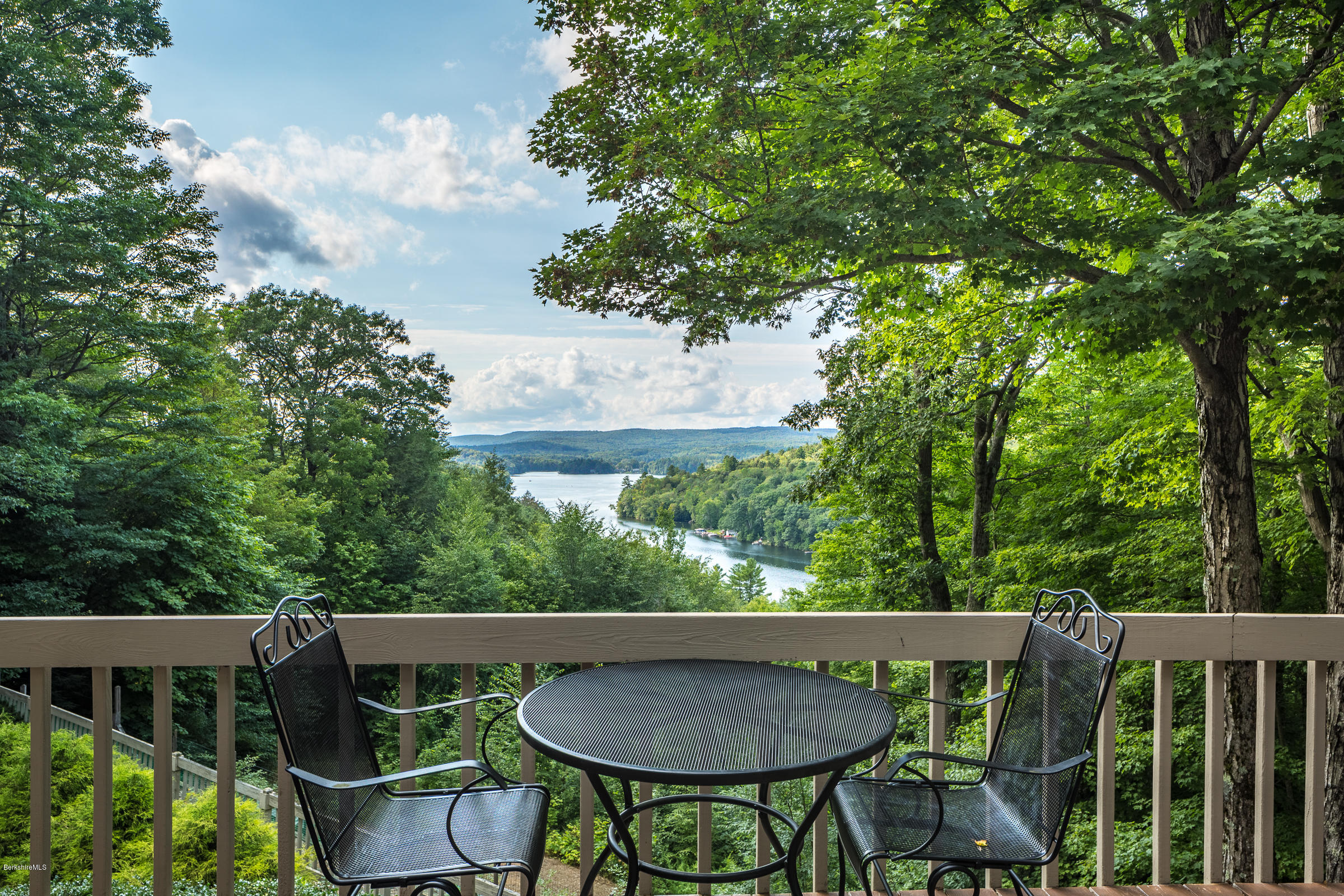 611 Main Road Monterey, MA 01245 - Photo 2 of 32 a balcony with wooden floor and fence