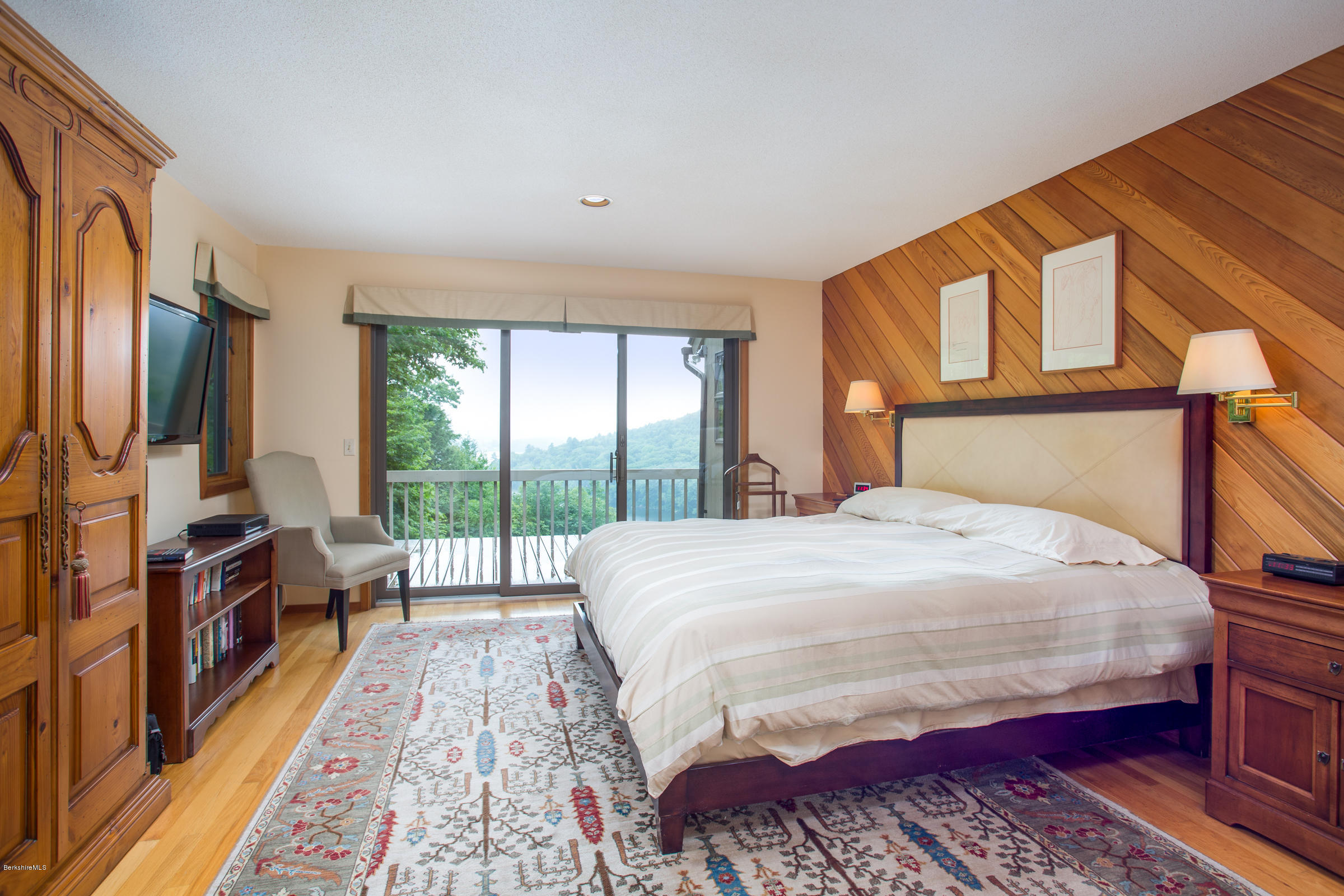 611 Main Road Monterey, MA 01245 - Photo 10 of 32 a bedroom with a bed a large window with wooden floor