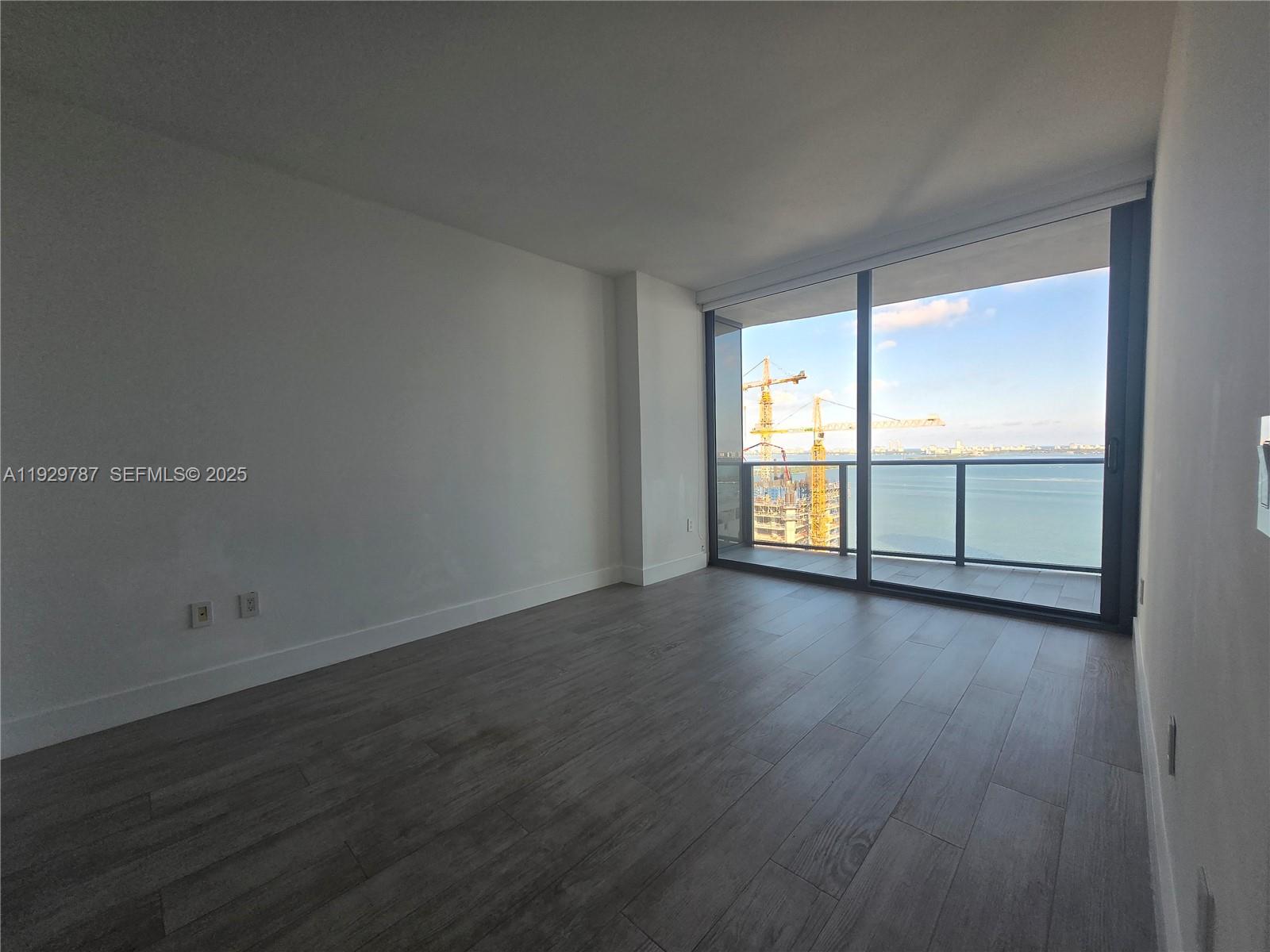 460 Northeast 28th Street, Unit 2407 Miami, FL 33137 - Photo 11 of 50 an empty room with wooden floor and windows