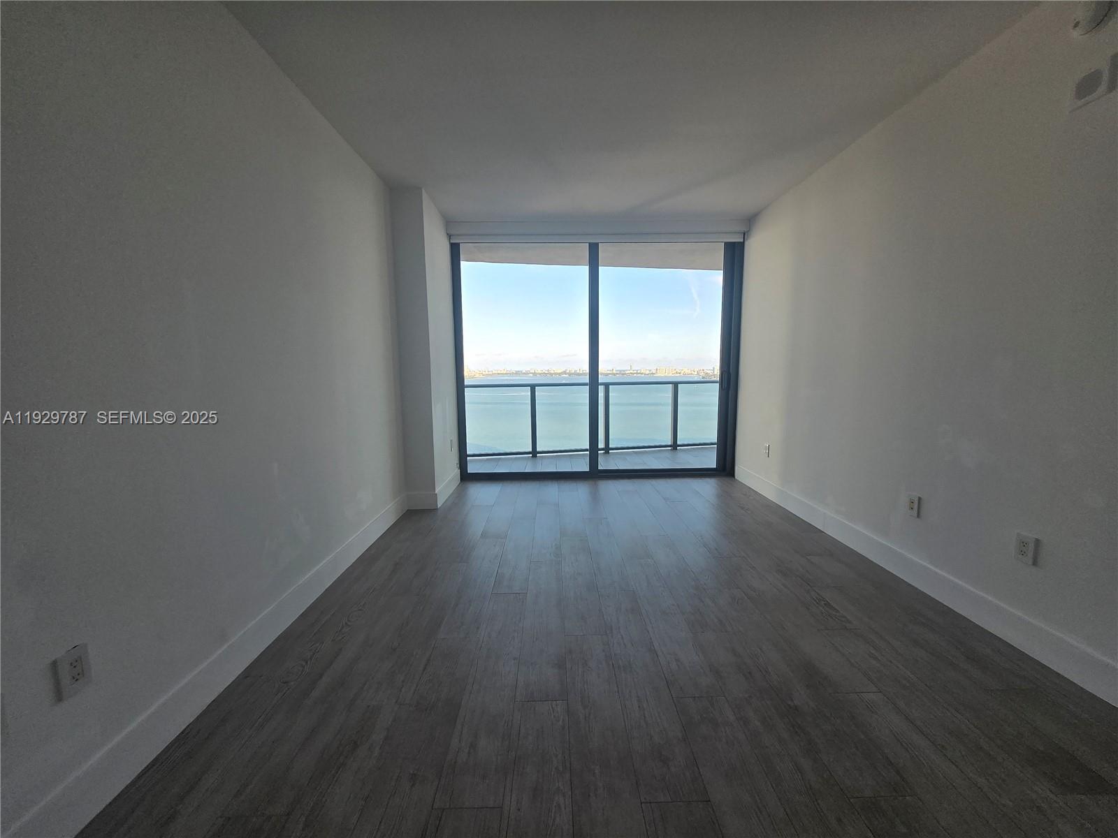 460 Northeast 28th Street, Unit 2407 Miami, FL 33137 - Photo 13 of 50 an empty room with wooden floor and windows
