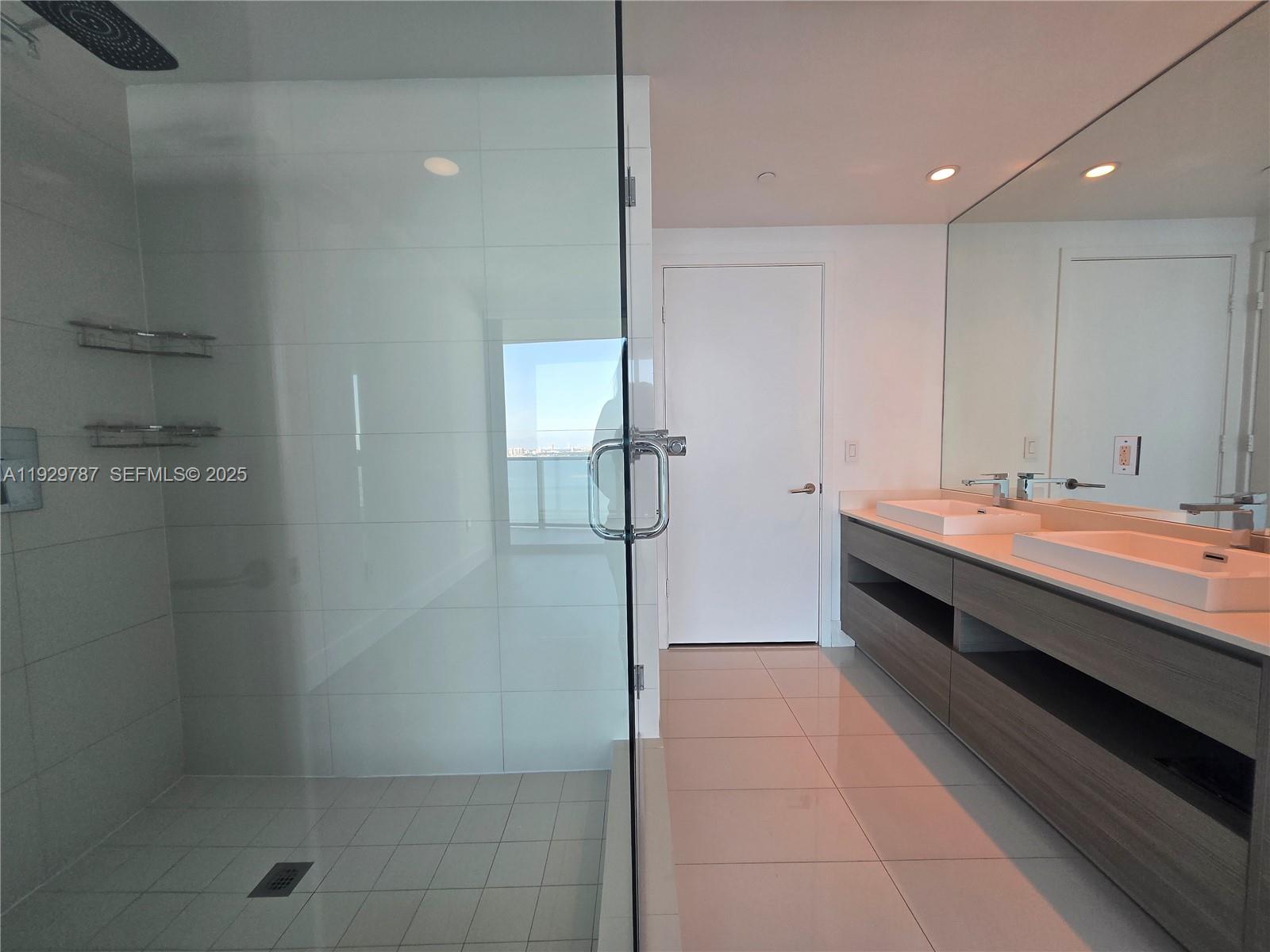 460 Northeast 28th Street, Unit 2407 Miami, FL 33137 - Photo 14 of 50 a bathroom with a double vanity sink a toilet and a mirror