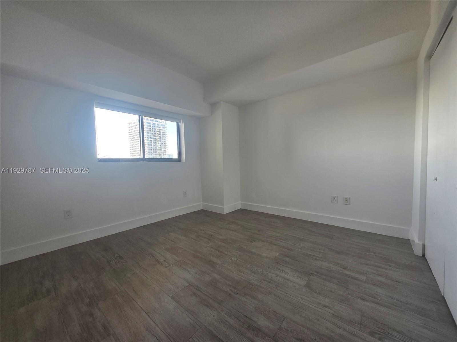 460 Northeast 28th Street, Unit 2407 Miami, FL 33137 - Photo 19 of 50 an empty room with wooden floor and windows