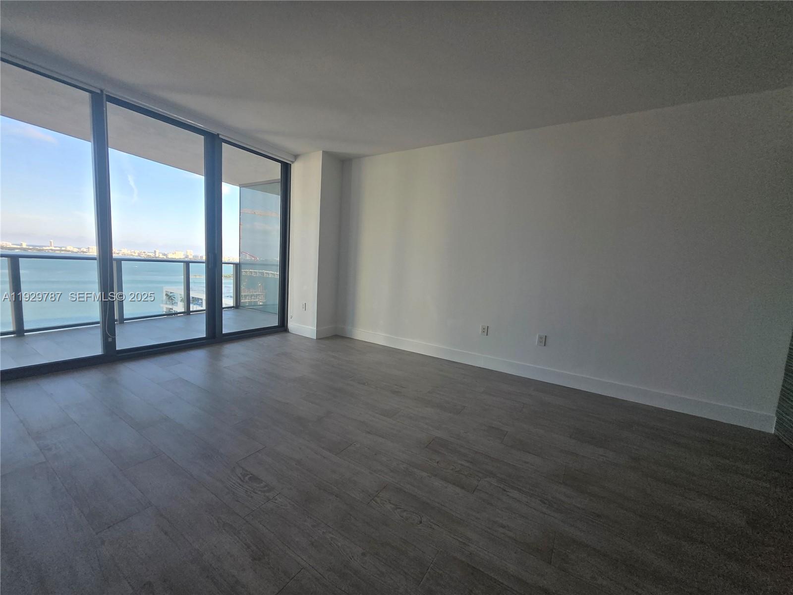 460 Northeast 28th Street, Unit 2407 Miami, FL 33137 - Photo 7 of 50 an empty room with wooden floor and windows