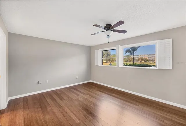 a view of empty room with wooden floor