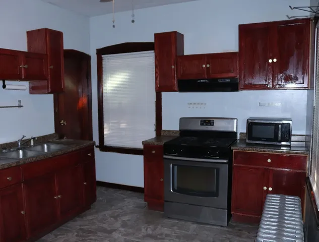a kitchen with granite countertop stainless steel appliances and wooden cabinets