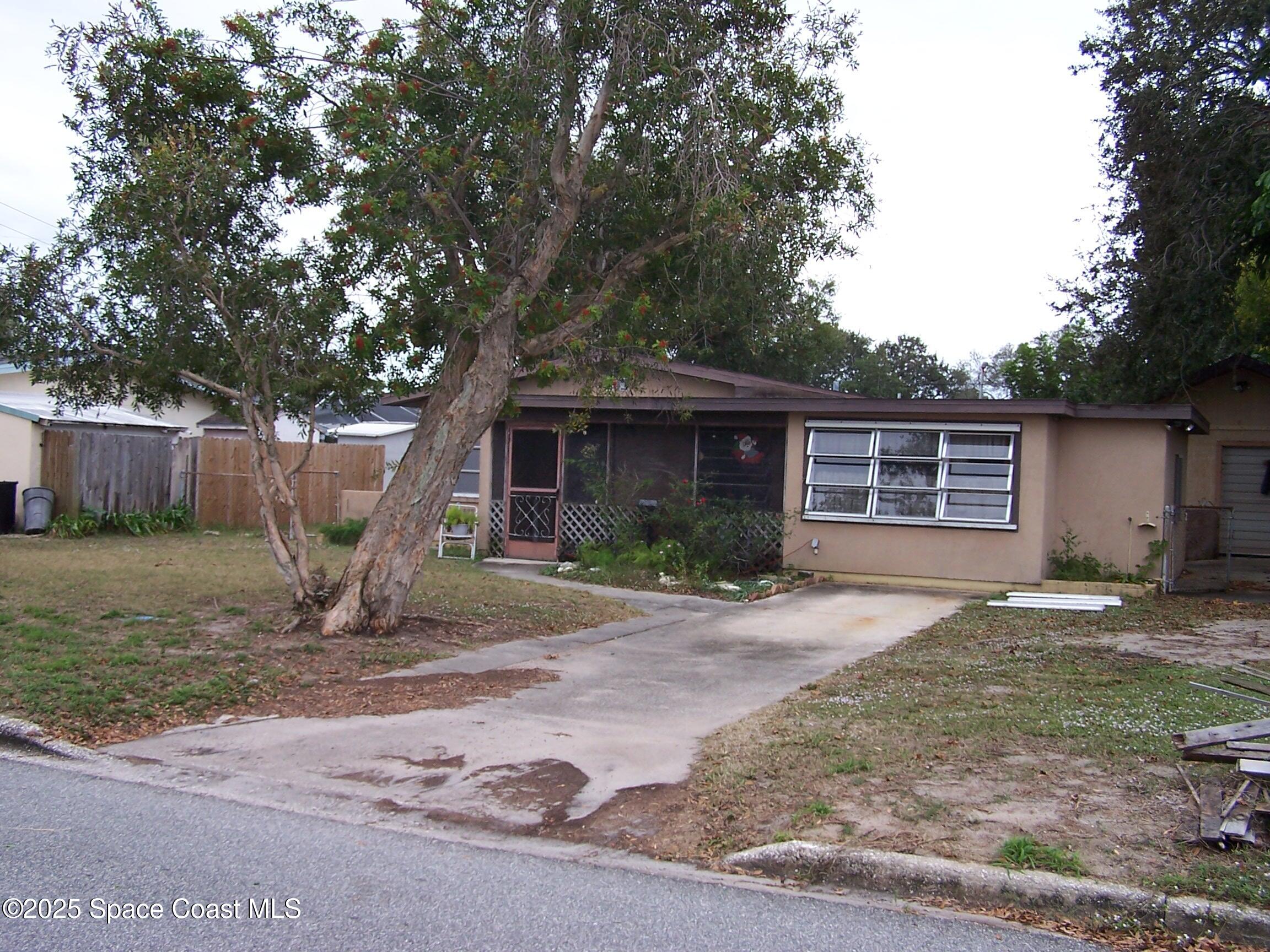 1545 Cunningham Avenue Merritt Island, FL 32952 - Photo 2 of 11 a view of a yard in front of a house with large tree