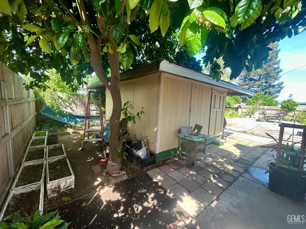 a backyard of a house with table and chairs potted plants