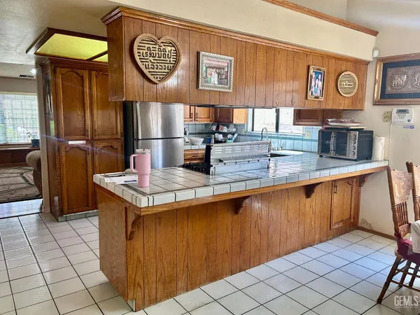 a kitchen with stainless steel appliances granite countertop a refrigerator a stove and a sink