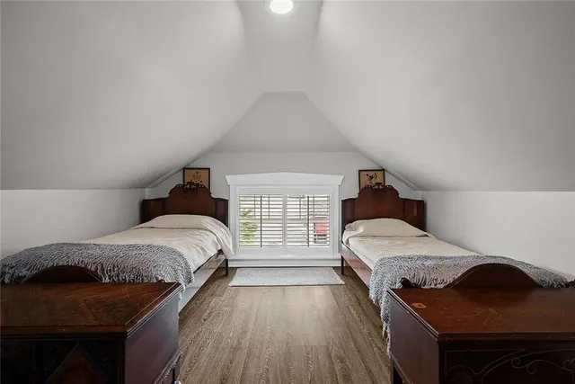 a spacious bedroom with a bed and wooden floor