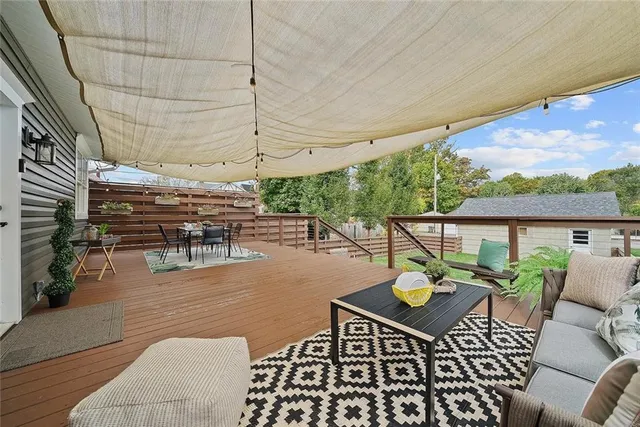 a view of a patio with table and chairs with wooden floor and fence