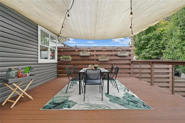 a view of a house with a small yard and a large tree