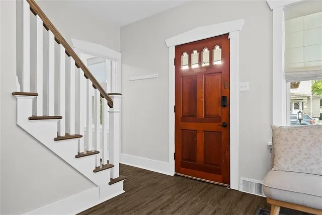 a view of an entryway with wooden floor and door