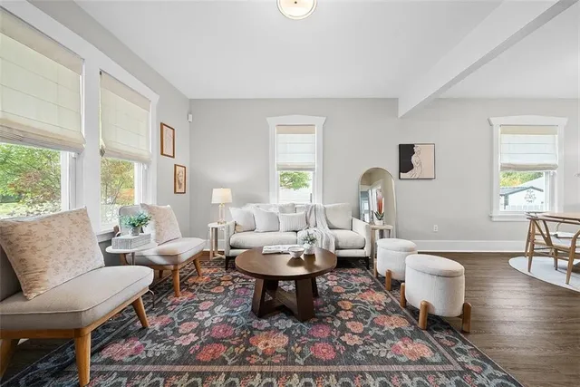 a living room with furniture a rug a lamp and a window