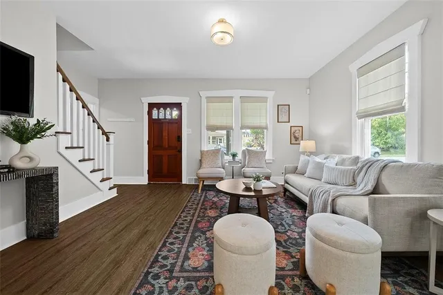 a living room with furniture a flat screen tv and a large window