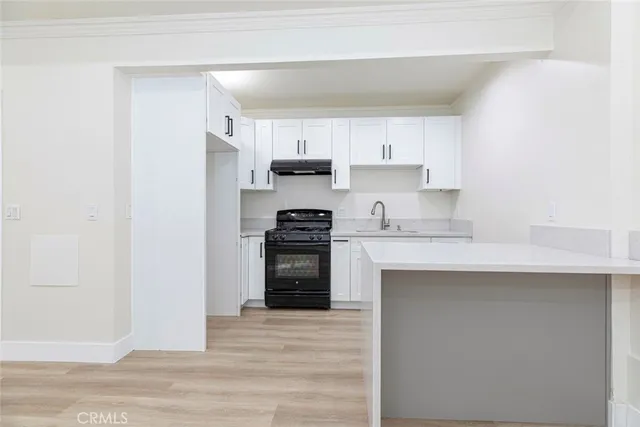 a kitchen with granite countertop a refrigerator stove top oven and sink