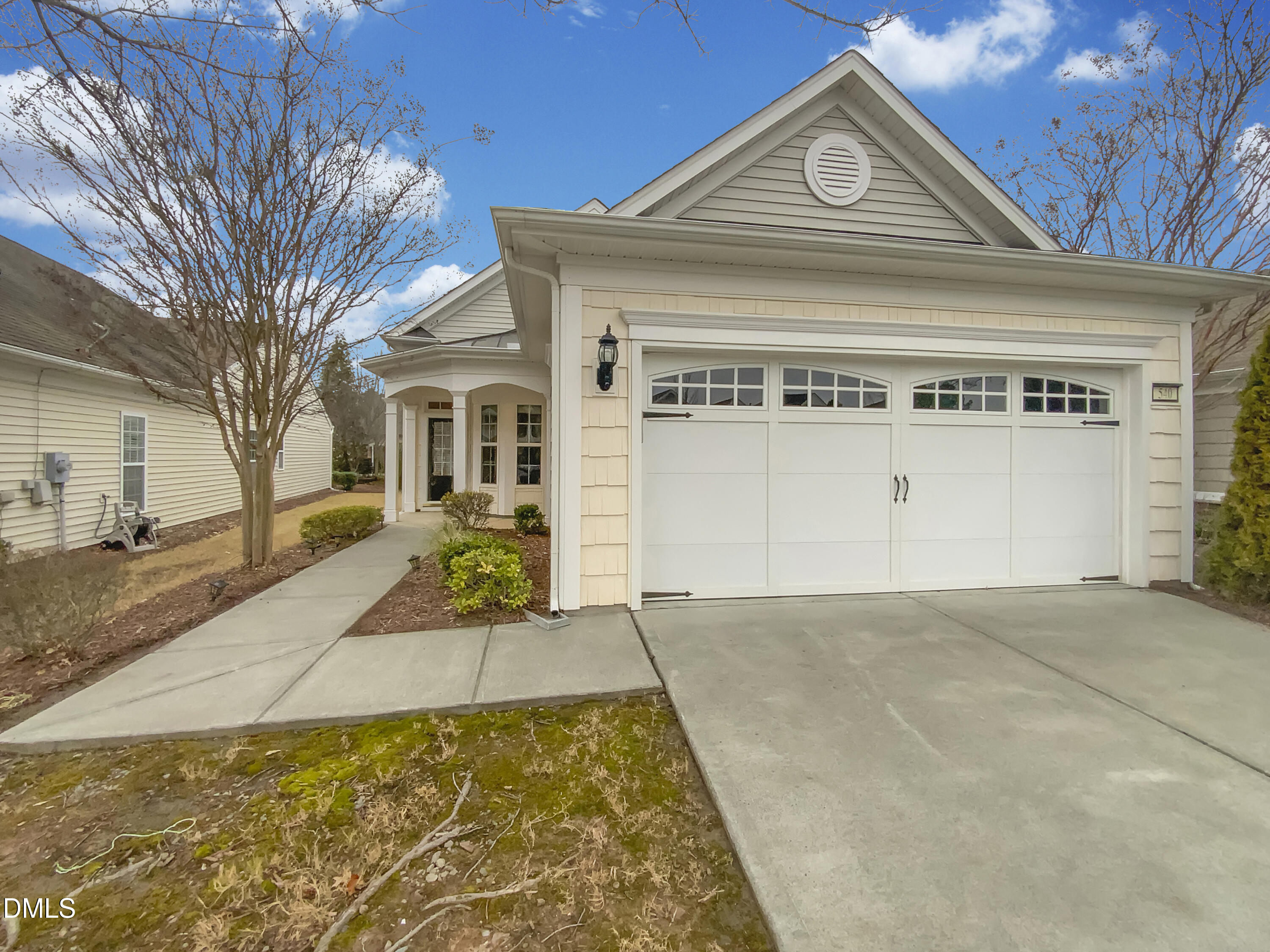 a view of a white house with a large tree