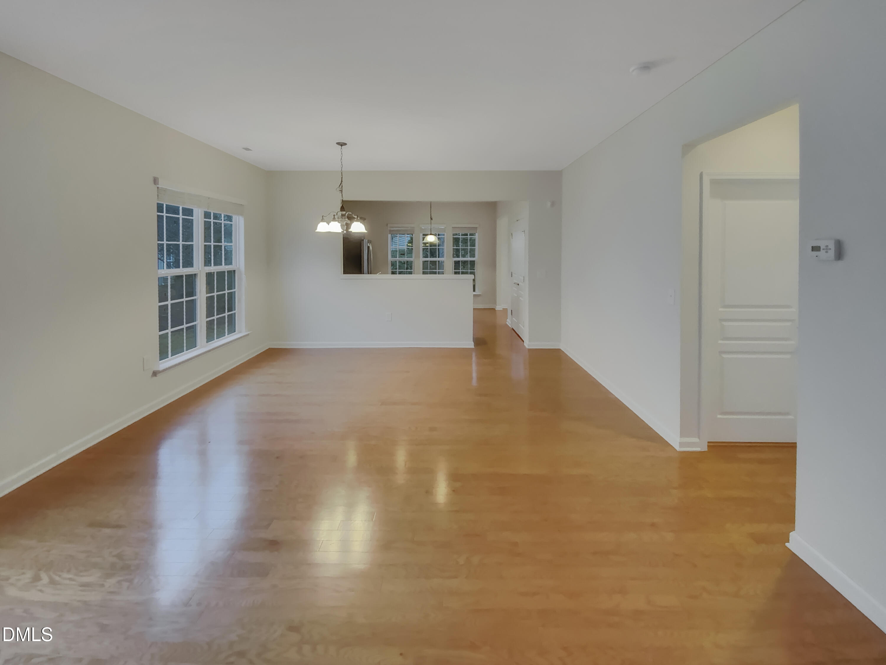 540 Tomkins Loop Cary, NC 27519 - Photo 3 of 19 a view of empty room with wooden floor and kitchen