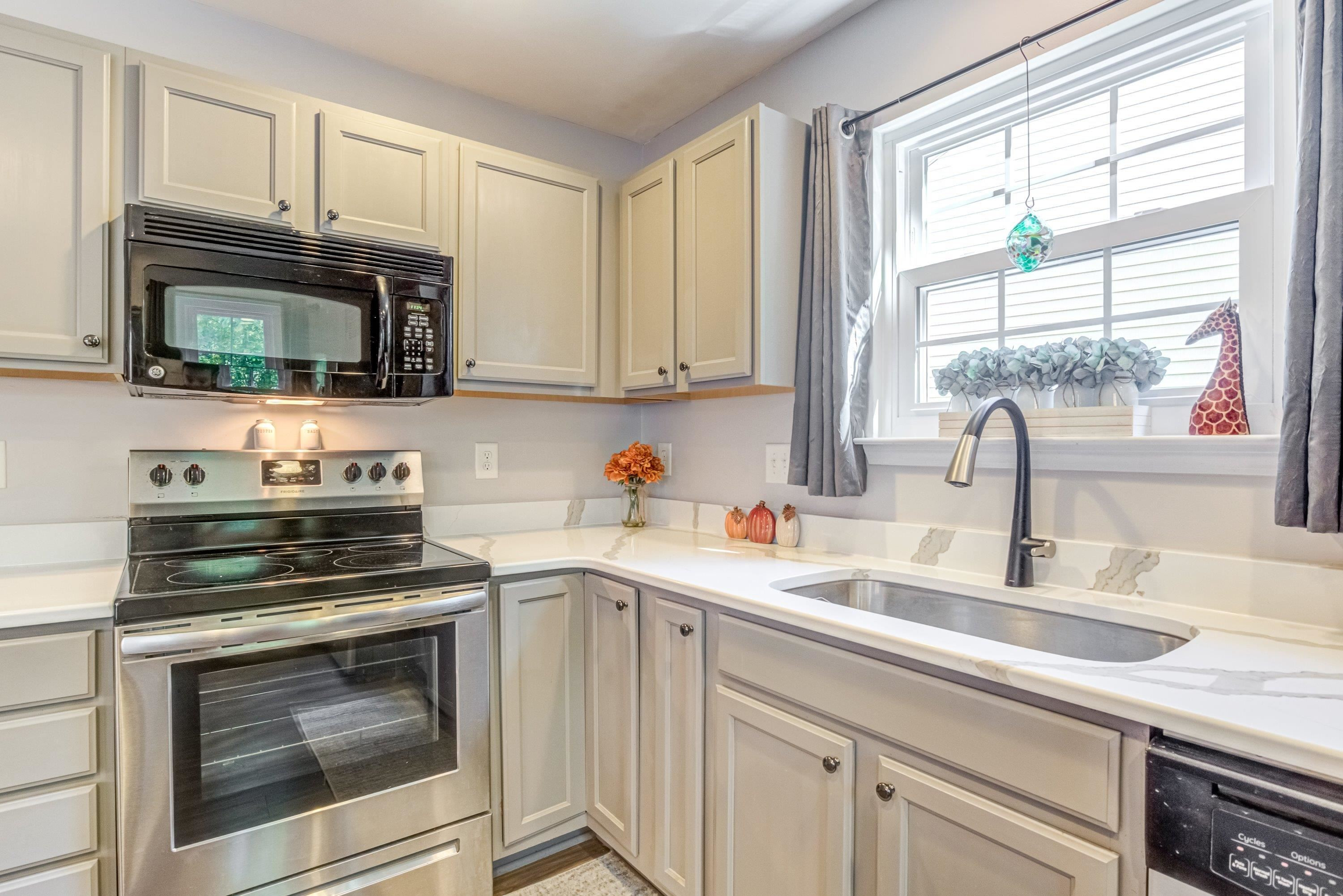 7726 Averette Field Drive Raleigh, NC 27616 - Photo 11 of 29 a kitchen with granite countertop a stove microwave and sink