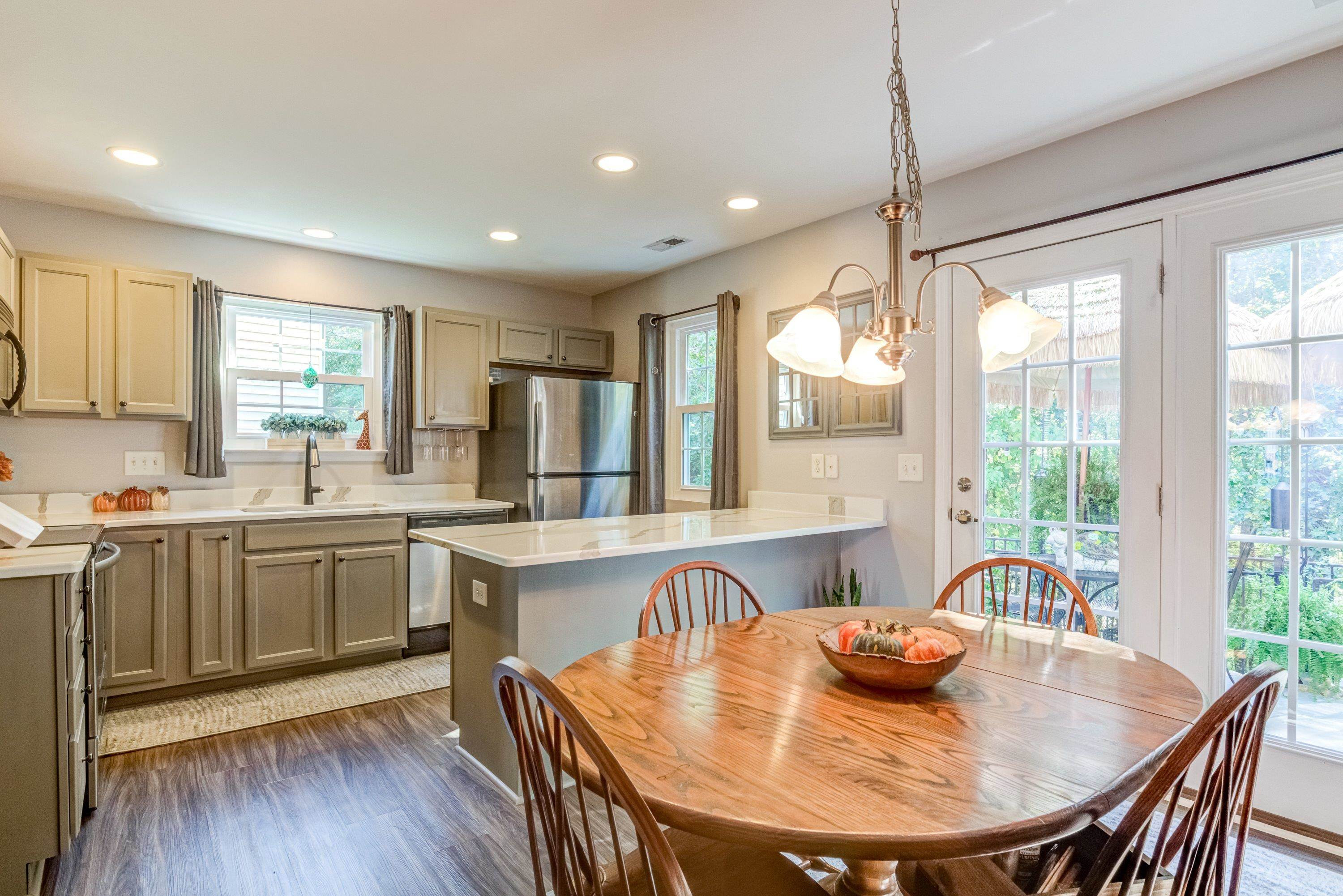 7726 Averette Field Drive Raleigh, NC 27616 - Photo 15 of 29 a kitchen with kitchen island granite countertop a stove a sink a refrigerator dining table and chairs
