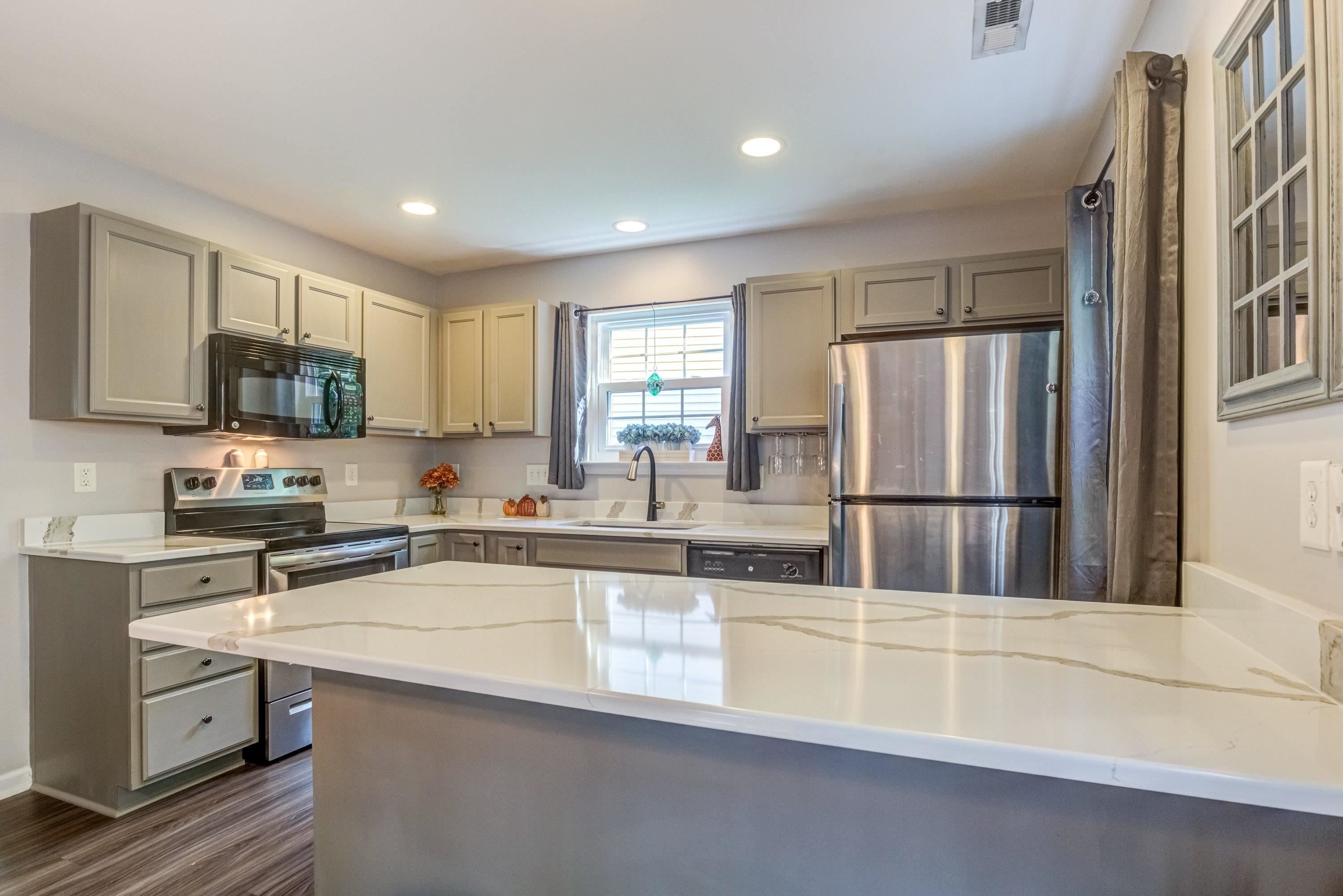 7726 Averette Field Drive Raleigh, NC 27616 - Photo 9 of 29 a kitchen with stainless steel appliances granite countertop a sink a stove a refrigerator cabinets and a counter top space