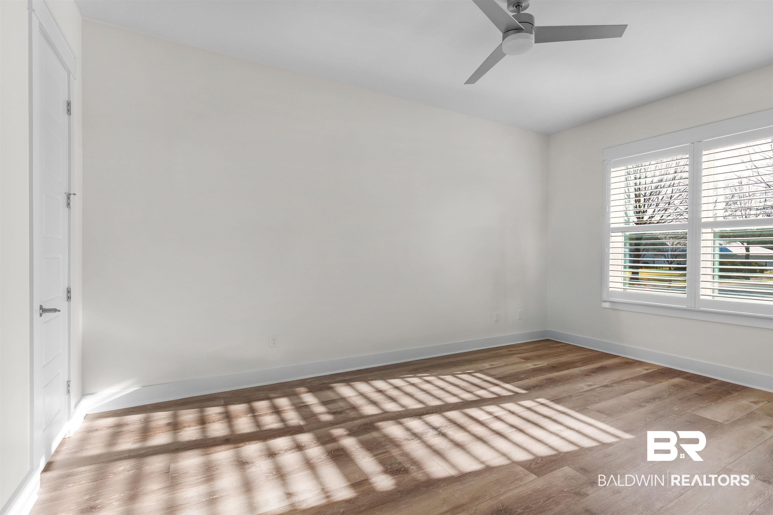 8069 Carmel Circle Foley, AL 36535 - Photo 10 of 23 Unfurnished room with baseboards, ceiling fan, and wood finished floors
