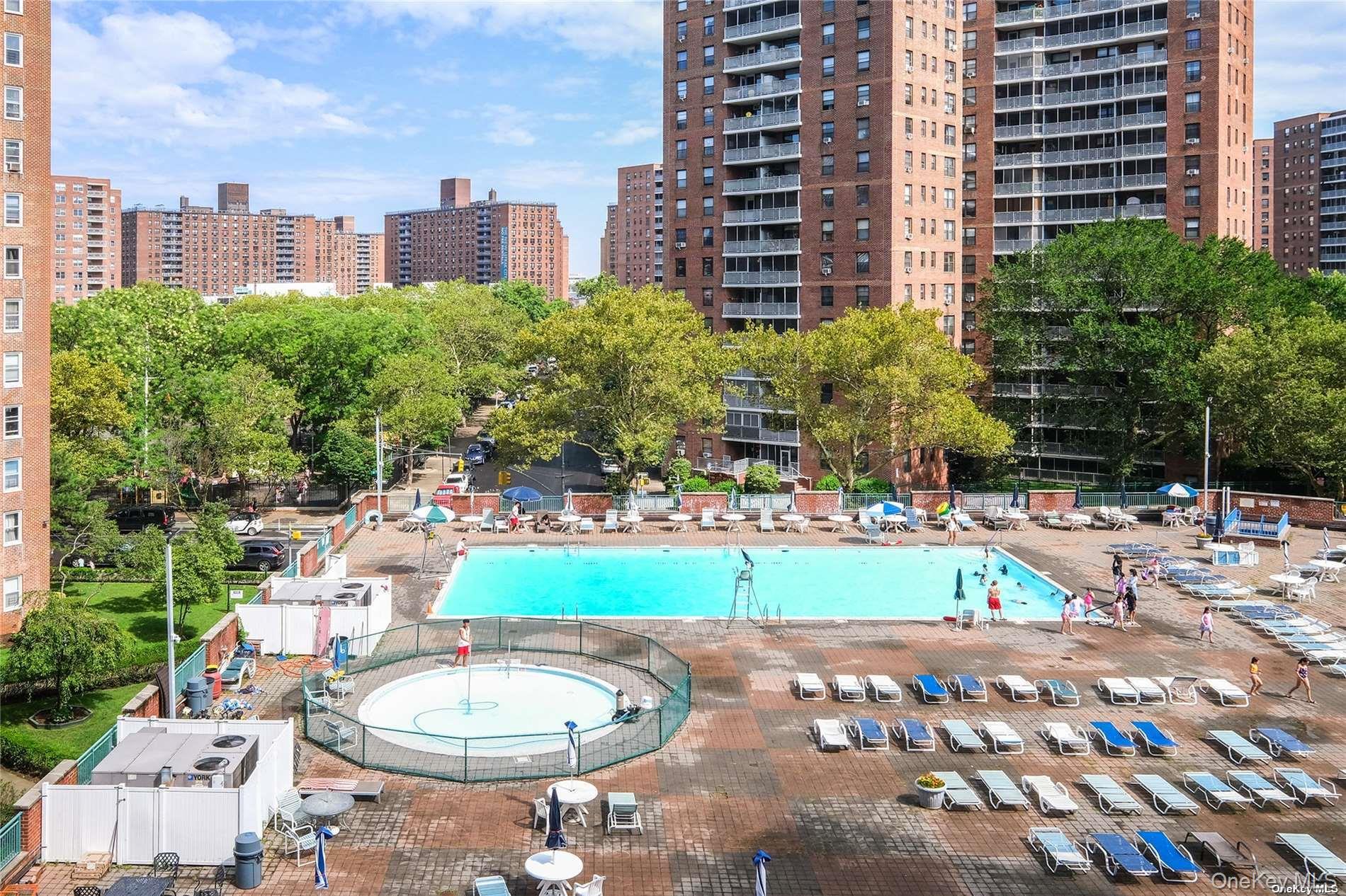 61-15 97th Street, Unit 12H Queens, NY 11374 - Photo 21 of 23 Community pool featuring a view of city and a patio