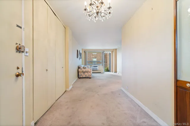 a view of a hallway with a chandelier and a livingroom