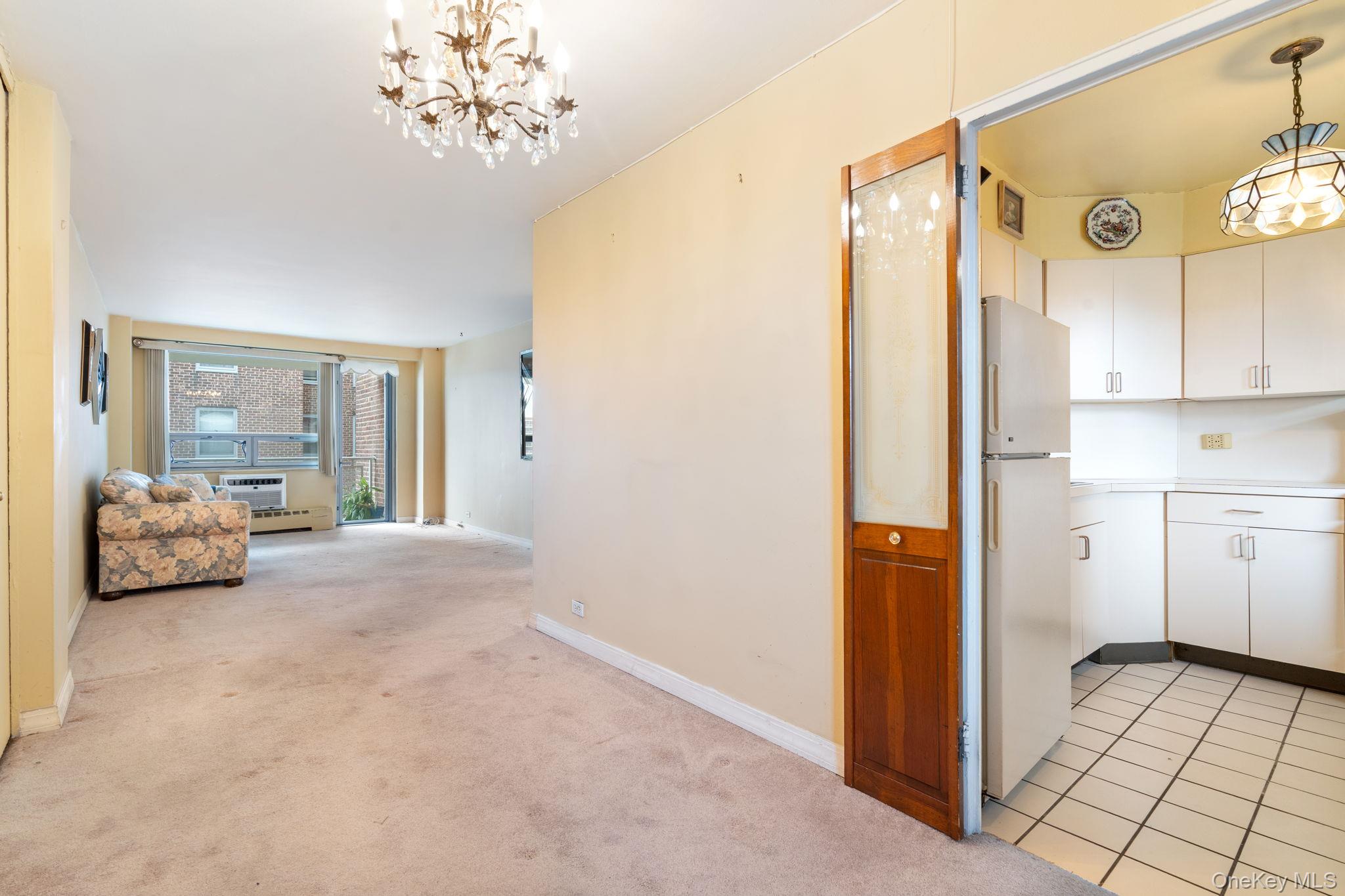 61-15 97th Street, Unit 12H Queens, NY 11374 - Photo 4 of 23 Hallway featuring a chandelier, light colored carpet, and light tile patterned floors