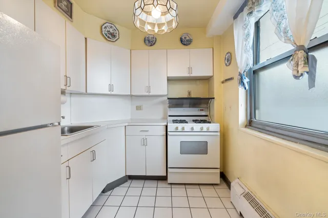 a kitchen with granite countertop white cabinets and white appliances