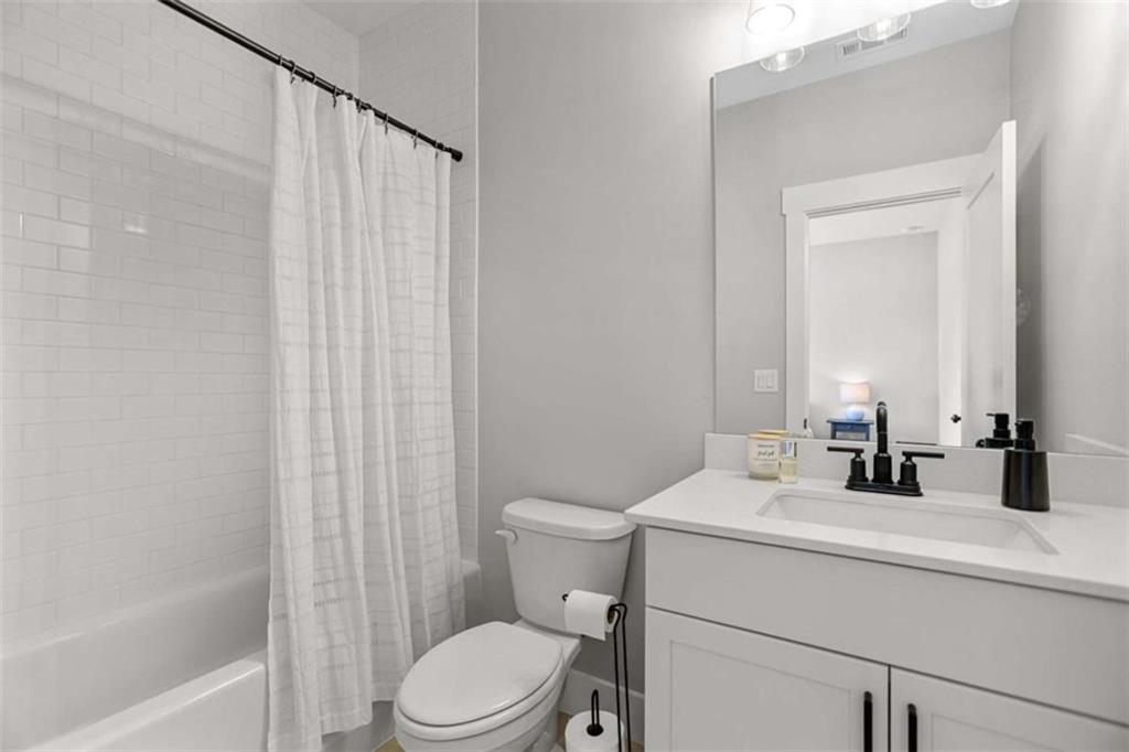 4466 Lemon Street Acworth, GA 30101 - Photo 42 of 65 a bathroom with a sink a toilet a mirror and shower