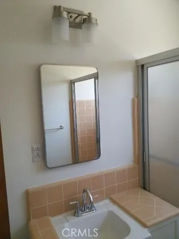 a bathroom with a granite countertop bathtub sink vanity mirror and toilet