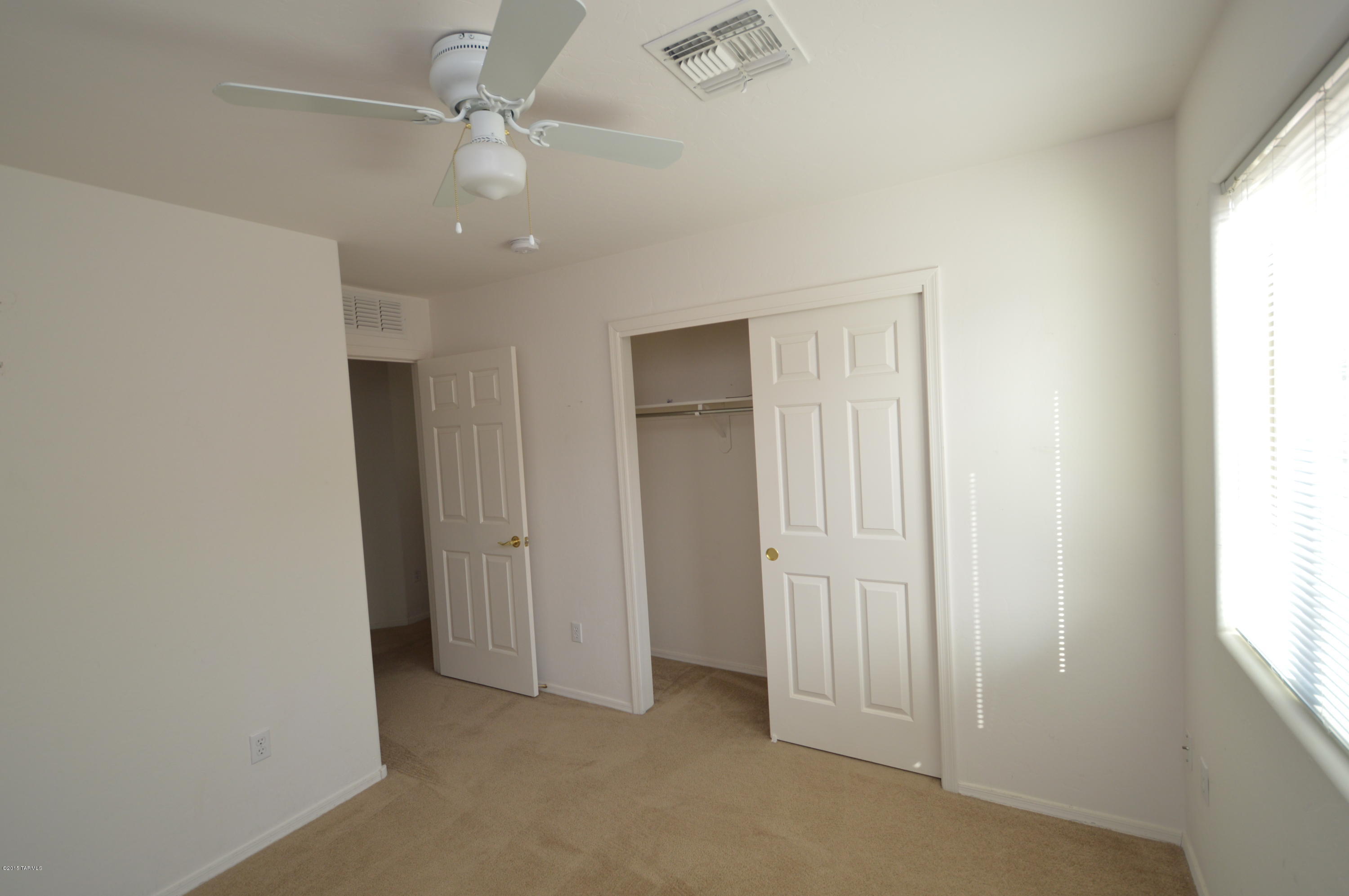 8396 West Benidorm Loop Tucson, AZ 85757 - Photo 7 of 13 an empty room with windows and fan