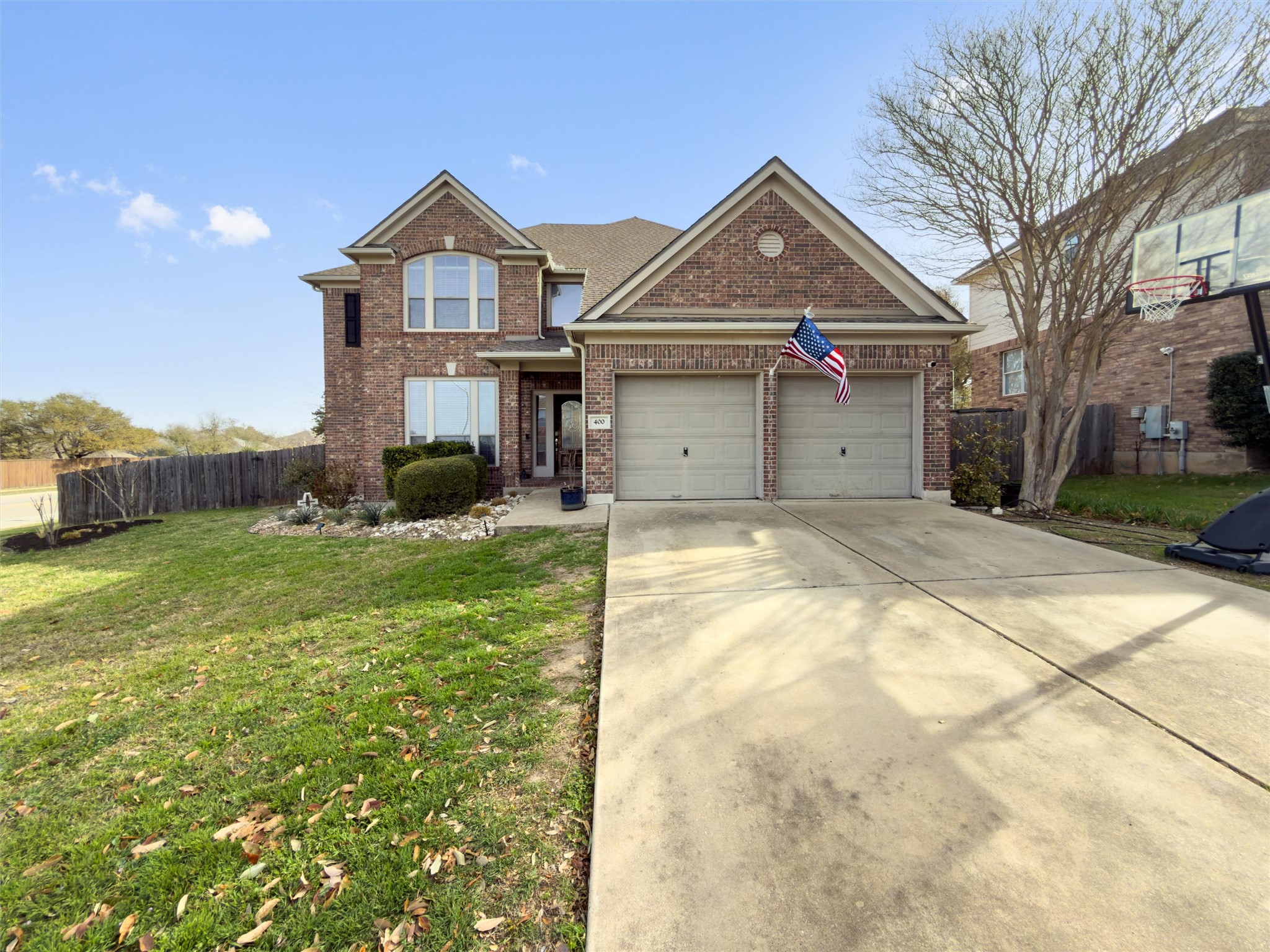 View of front of property featuring driveway, an attached garage, and brick siding