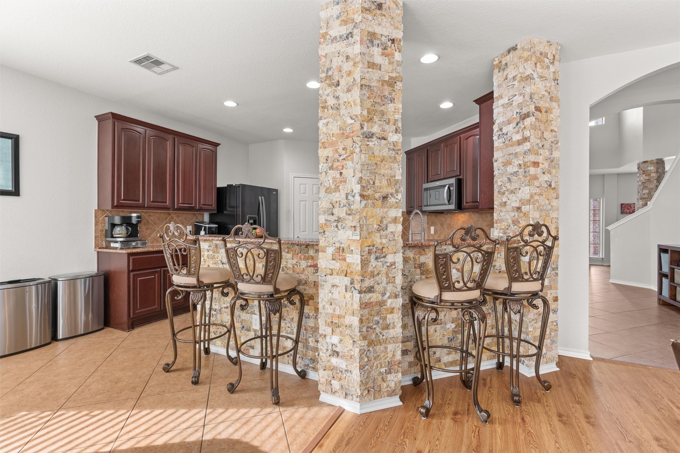 400 Red Hawk Drive Leander, TX 78641 - Photo 10 of 36 Kitchen with a breakfast bar, tasteful backsplash, arched walkways, light tile patterned floors, and recessed lighting