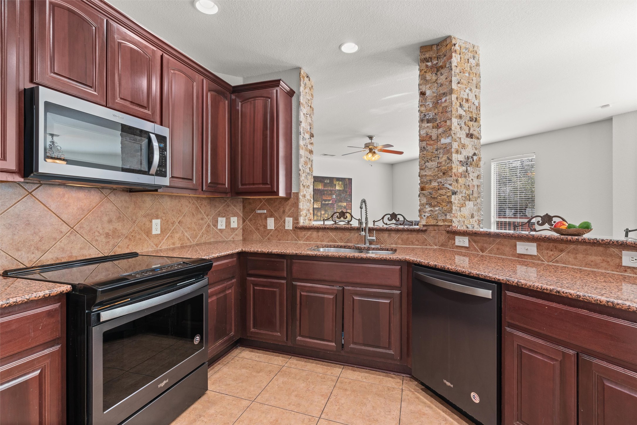 400 Red Hawk Drive Leander, TX 78641 - Photo 12 of 36 Kitchen featuring stainless steel appliances, light stone counters, a ceiling fan, light tile patterned flooring, and recessed lighting