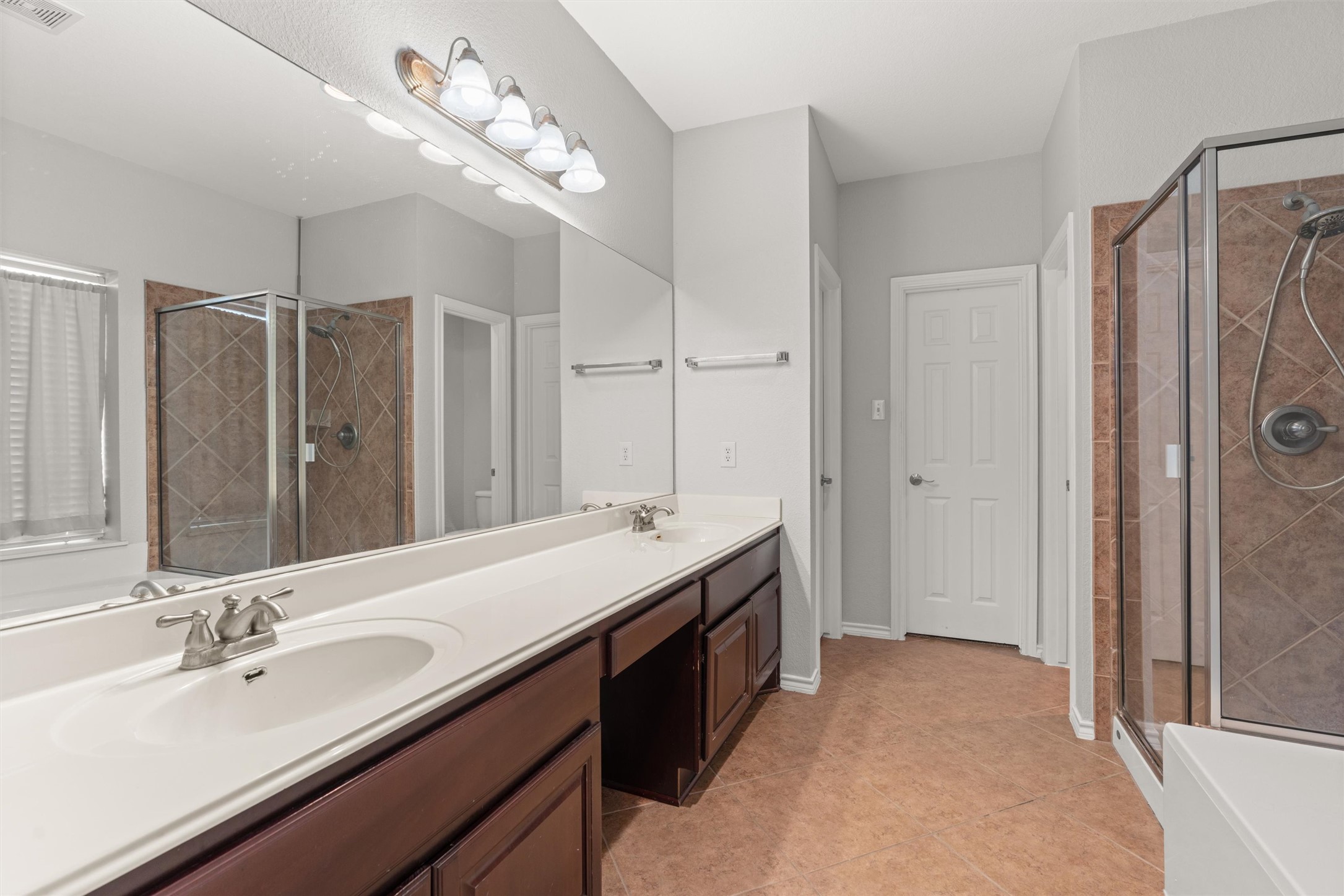 400 Red Hawk Drive Leander, TX 78641 - Photo 17 of 36 Bathroom featuring a shower stall, double vanity, and light tile patterned floors