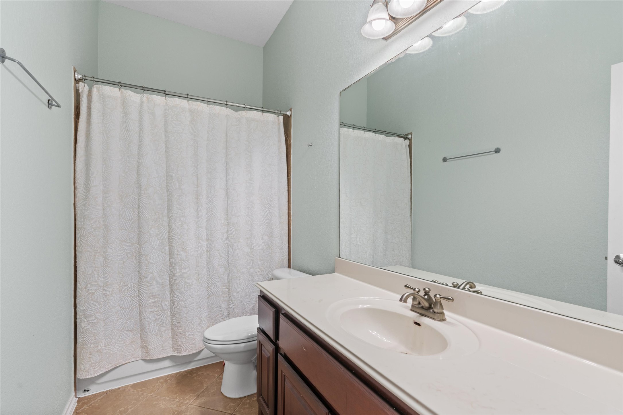 400 Red Hawk Drive Leander, TX 78641 - Photo 24 of 36 Bathroom featuring vanity, light tile patterned flooring, and shower / bathtub combination with curtain