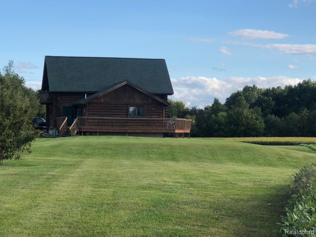 10374 Wilson Road Otisville, MI 48463 - Photo 21 of 99 View of side of property featuring a yard, log siding, and a wooden deck