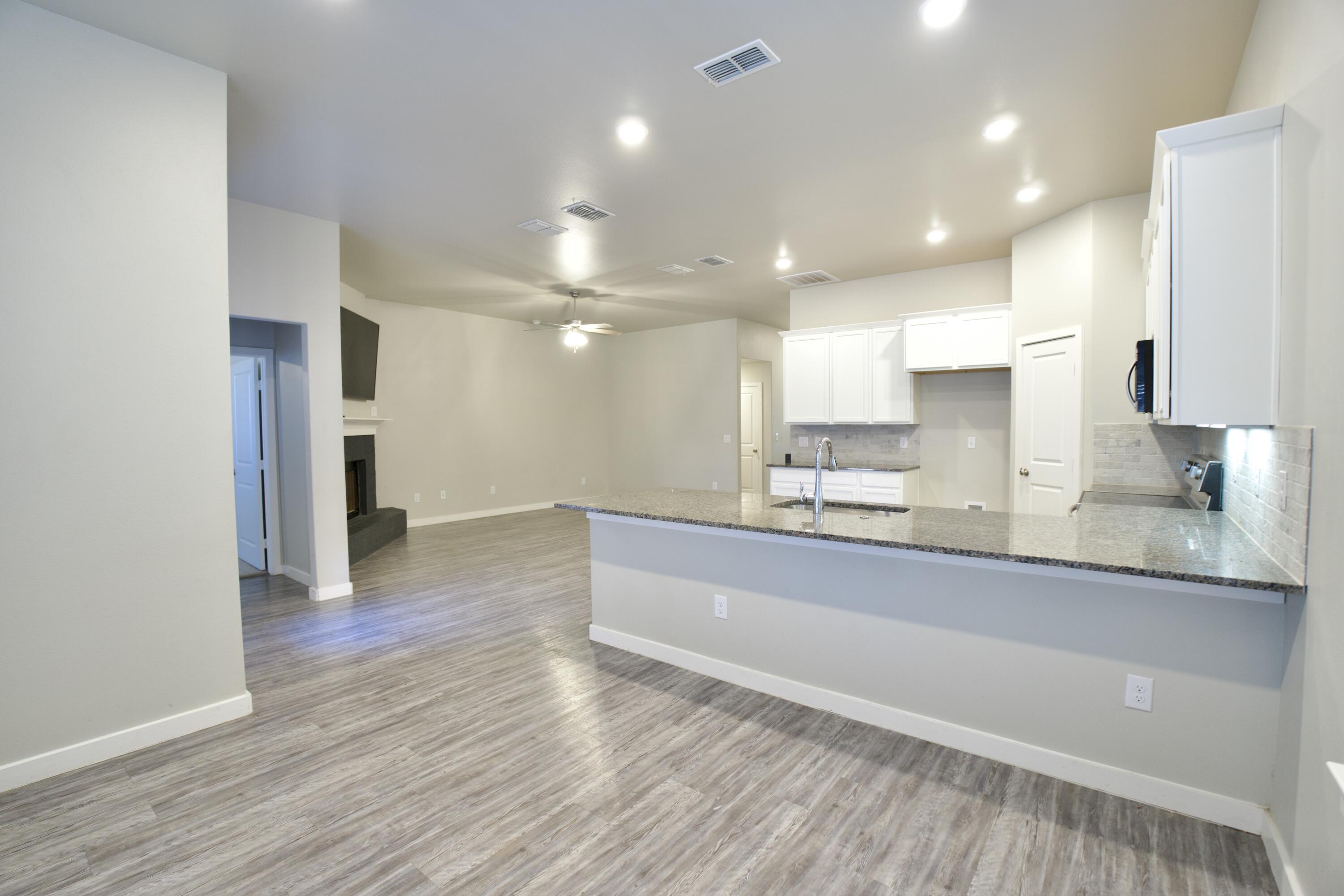 1604 137th Street Lubbock, TX 79423 - Photo 8 of 19 a large kitchen with kitchen island a sink stainless steel appliances and cabinets