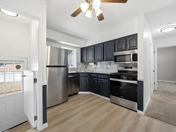 a kitchen with stainless steel appliances granite countertop a refrigerator stove and a sink